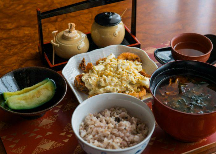 A Japan set meal of many different dishes, including miso soup, rice, pickled veggies, and more.